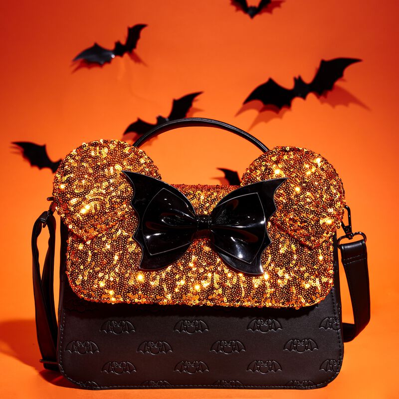 Image of our Minnie Mouse Halloween Sequin Crossbody Bag against an orange background with bats